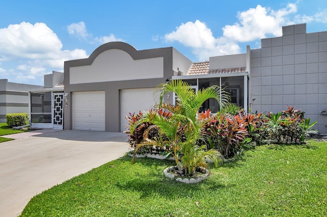 view of front facade featuring a sunroom, a garage, and a front yard