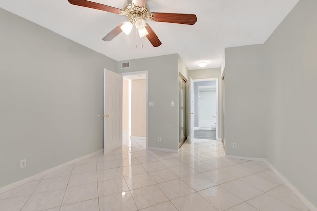 empty room with light tile patterned floors and ceiling fan