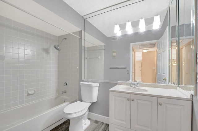 full bathroom with toilet, hardwood / wood-style floors, vanity, and tiled shower / bath