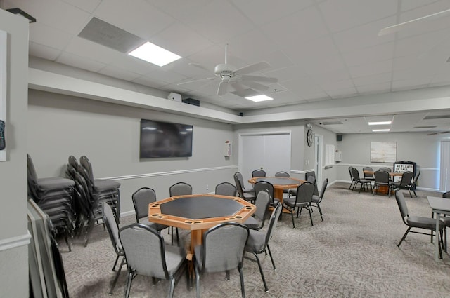 carpeted dining area featuring a paneled ceiling and ceiling fan