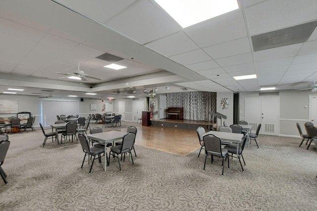 dining area featuring a paneled ceiling, ceiling fan, and hardwood / wood-style flooring