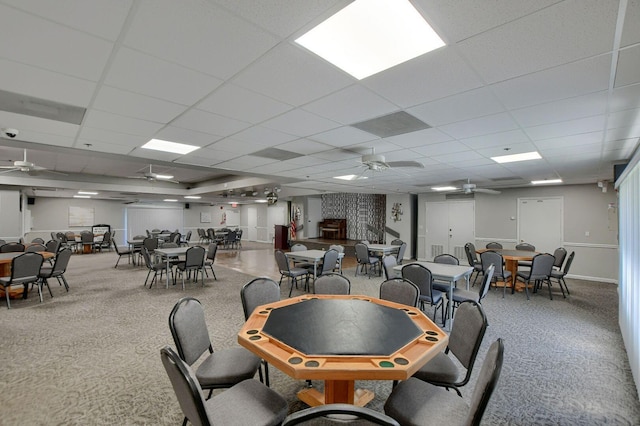 dining room with a paneled ceiling, ceiling fan, and carpet