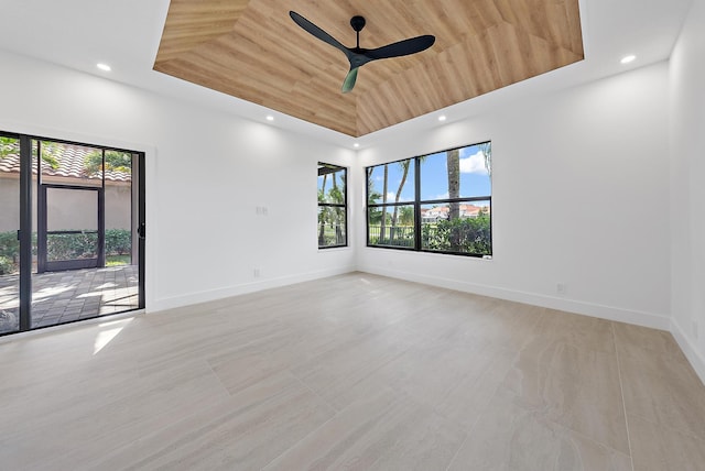 spare room with a raised ceiling, ceiling fan, a towering ceiling, and wood ceiling