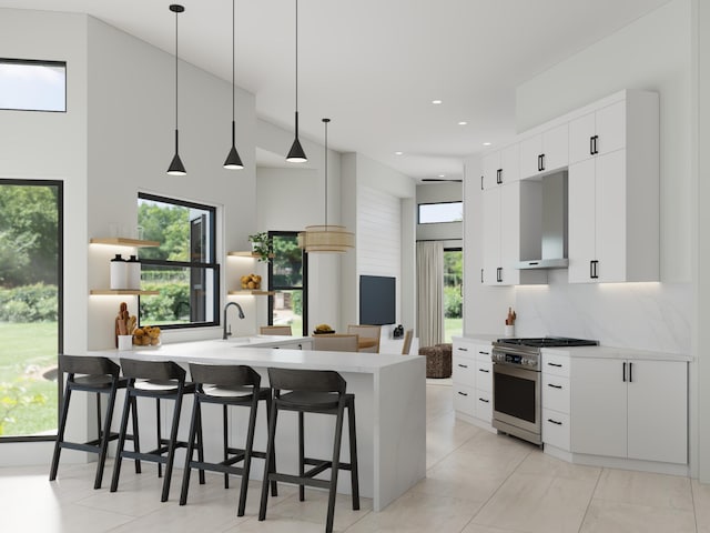 kitchen featuring a breakfast bar, kitchen peninsula, stainless steel stove, and wall chimney range hood