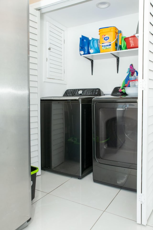 laundry room with washer and clothes dryer and tile patterned flooring