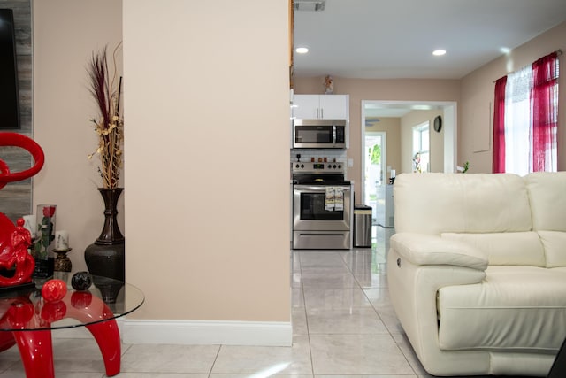 kitchen featuring white cabinetry, appliances with stainless steel finishes, and light tile patterned flooring