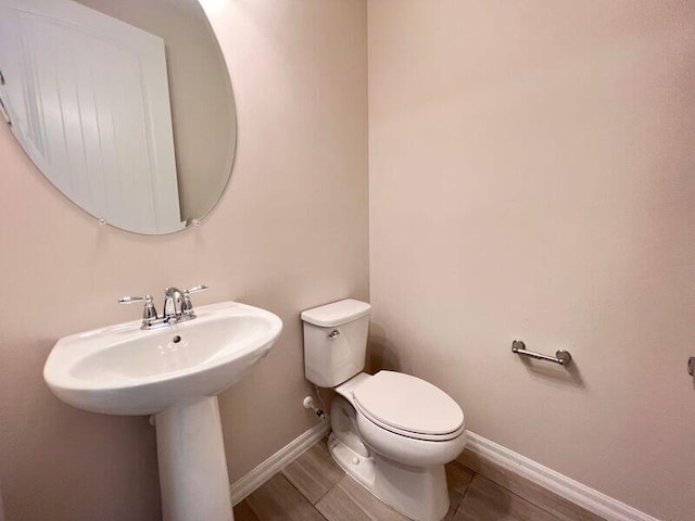 bathroom with hardwood / wood-style floors and toilet