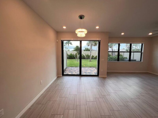 interior space with a chandelier, a wealth of natural light, and light hardwood / wood-style flooring