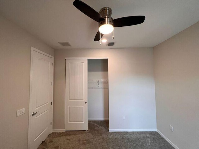 unfurnished bedroom featuring ceiling fan, a closet, and dark carpet