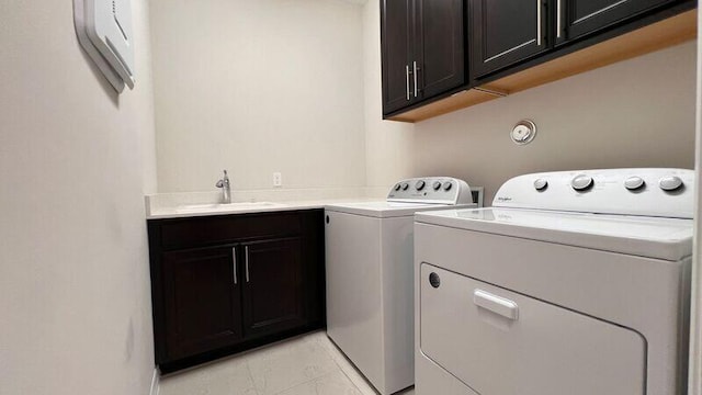 clothes washing area with cabinets, separate washer and dryer, and sink