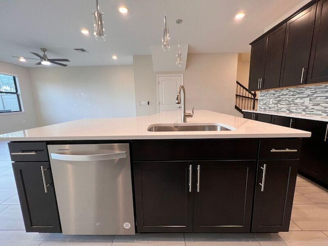 kitchen with dishwasher, tasteful backsplash, sink, and an island with sink