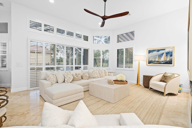 living room with a high ceiling and ceiling fan