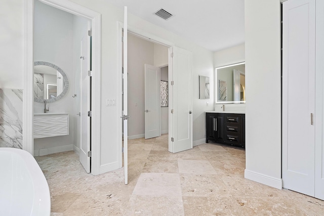 bathroom featuring vanity and a washtub