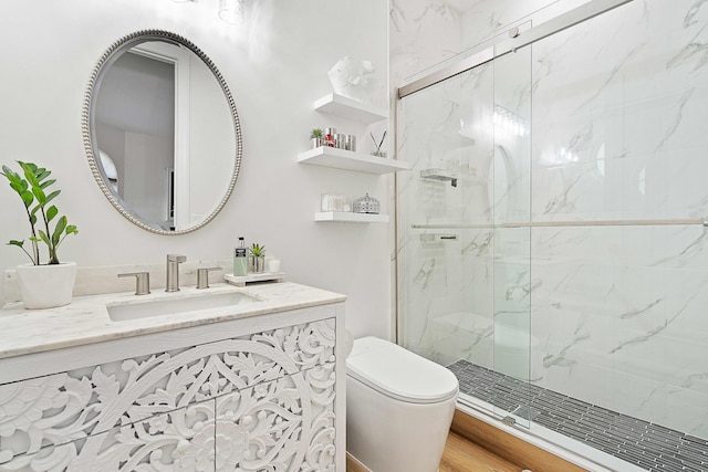 bathroom with vanity, a shower with door, and toilet