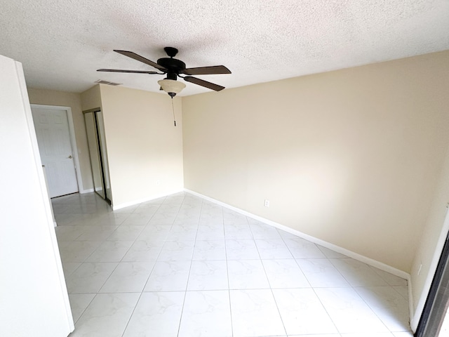 spare room with a textured ceiling and ceiling fan