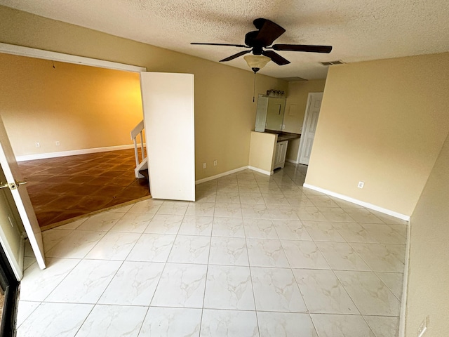 spare room featuring a textured ceiling and ceiling fan