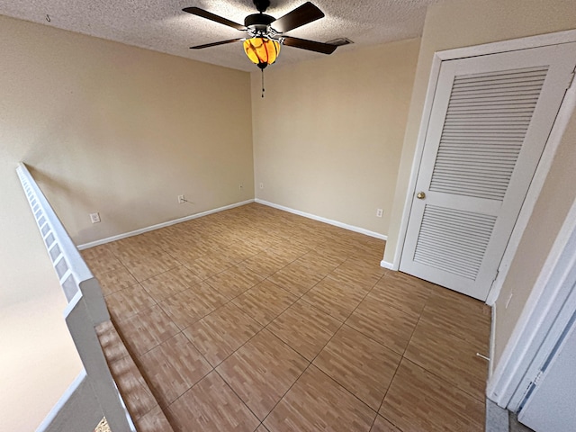 interior space with a textured ceiling and ceiling fan