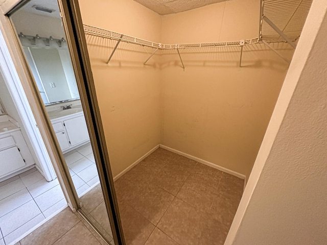 spacious closet with tile patterned floors