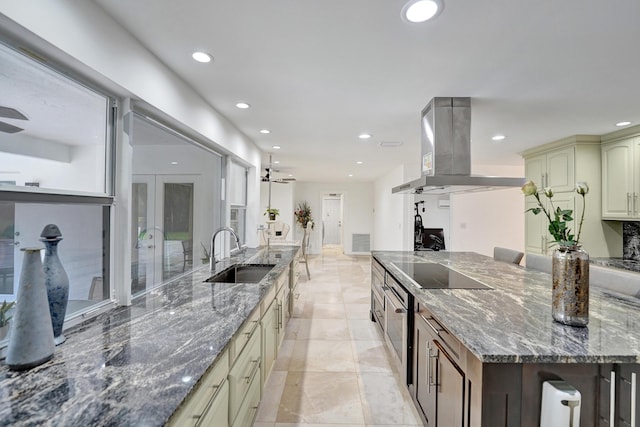 kitchen with cream cabinetry, extractor fan, dark stone counters, and sink