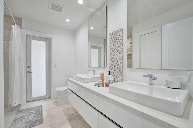 bathroom with tile patterned flooring, vanity, and toilet