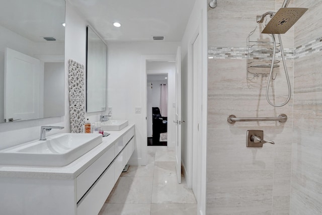 bathroom featuring a tile shower and vanity