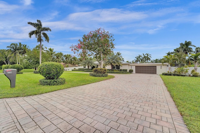 ranch-style home featuring a garage and a front lawn