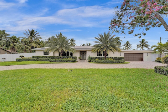 view of front of home with a front lawn and a garage