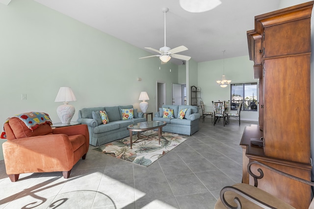 tiled living room featuring ceiling fan with notable chandelier and high vaulted ceiling