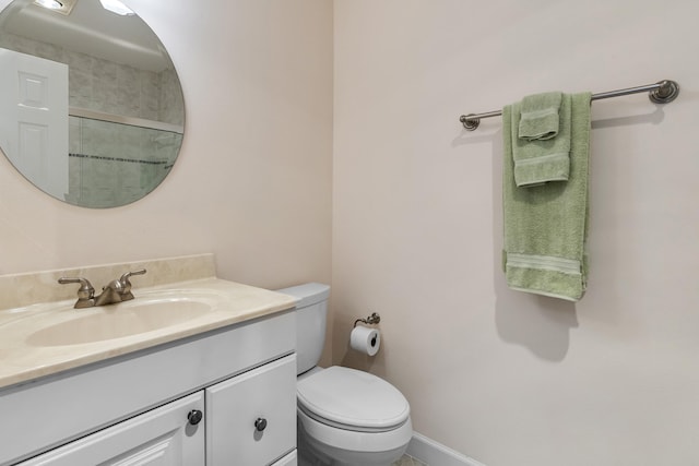 bathroom featuring a shower with shower door, toilet, and vanity