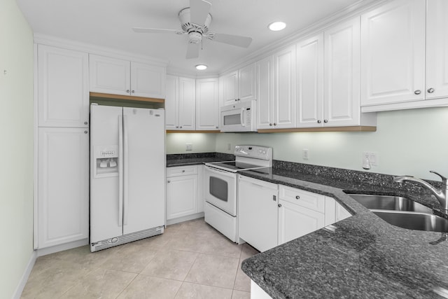 kitchen featuring sink, white cabinetry, dark stone counters, light tile patterned flooring, and white appliances