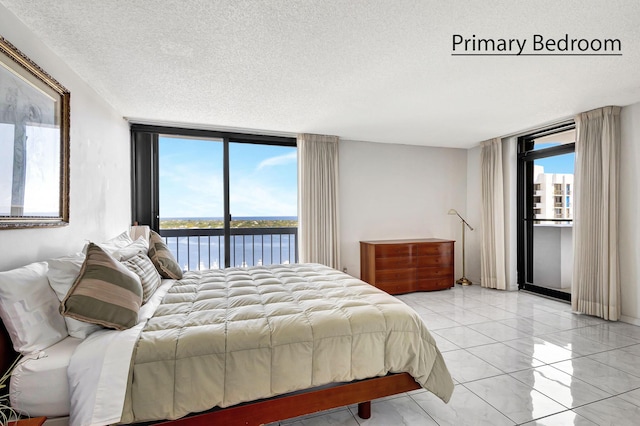 bedroom featuring expansive windows, a water view, and multiple windows