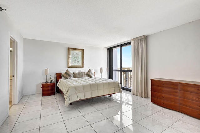 bedroom with floor to ceiling windows, a textured ceiling, and access to exterior