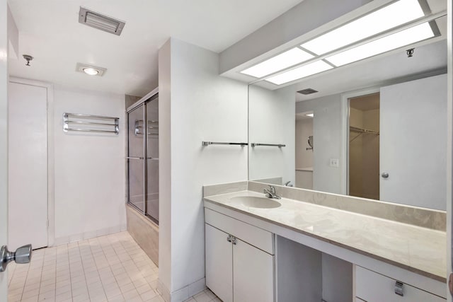 bathroom with tile patterned flooring, vanity, and combined bath / shower with glass door