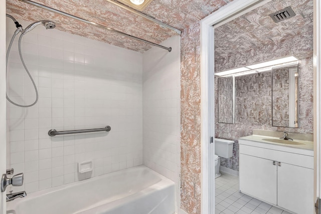 full bathroom featuring tile patterned flooring, tiled shower / bath combo, toilet, and vanity