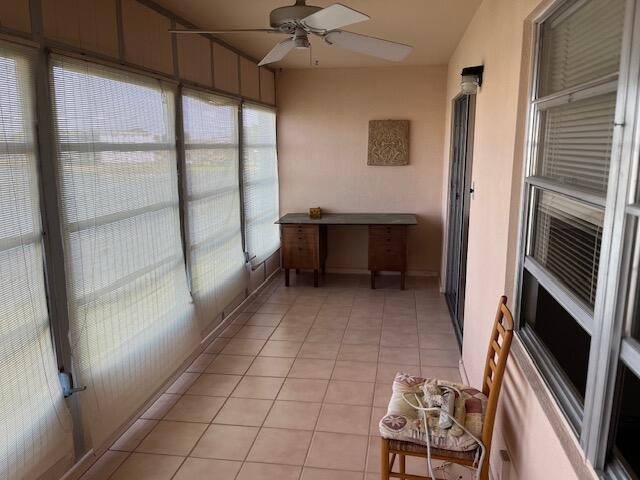 unfurnished sunroom with ceiling fan