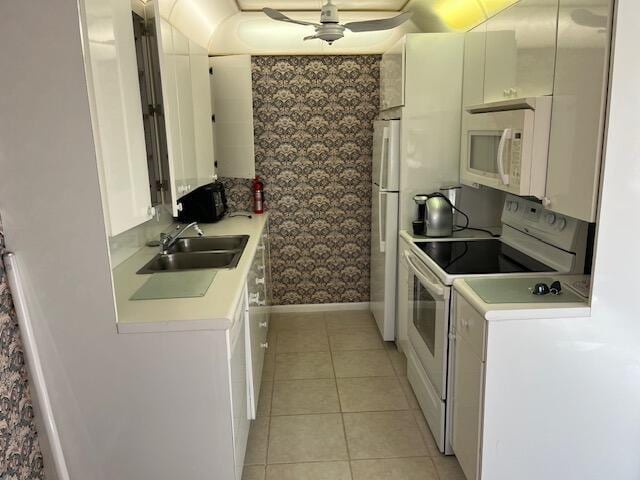 kitchen featuring sink, white cabinets, white appliances, and light tile patterned floors