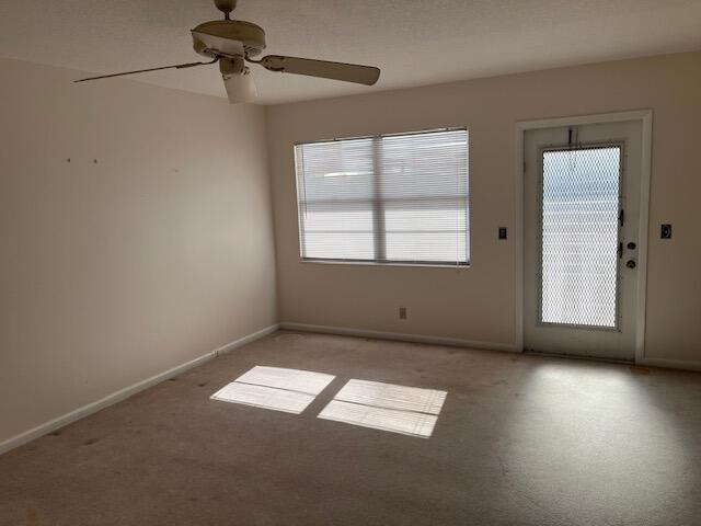 spare room with light carpet and ceiling fan