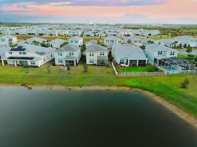 aerial view at dusk featuring a water view