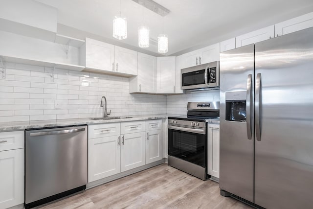 kitchen featuring white cabinets, light hardwood / wood-style floors, sink, and appliances with stainless steel finishes