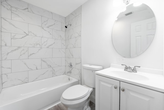 full bathroom featuring tiled shower / bath combo, toilet, and vanity