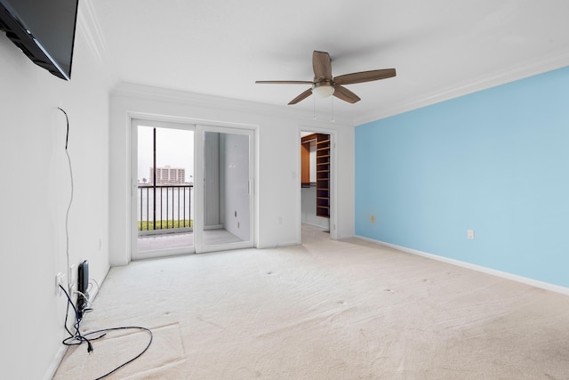 carpeted empty room featuring ceiling fan and ornamental molding