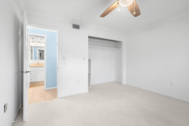 unfurnished bedroom featuring ceiling fan, crown molding, light carpet, and a closet