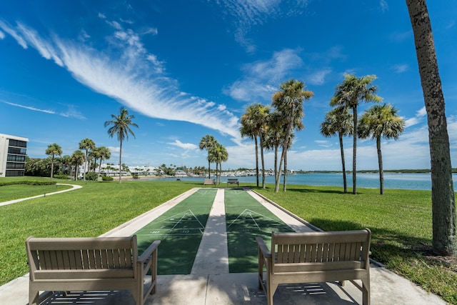 view of property's community with a water view and a lawn