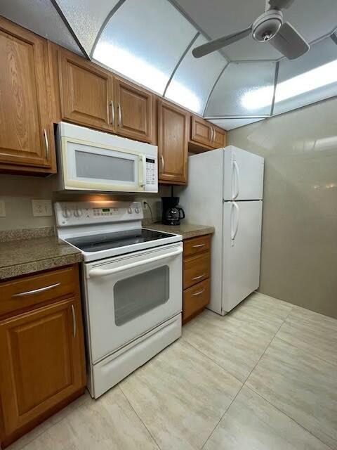 kitchen with ceiling fan, light tile patterned flooring, and white appliances