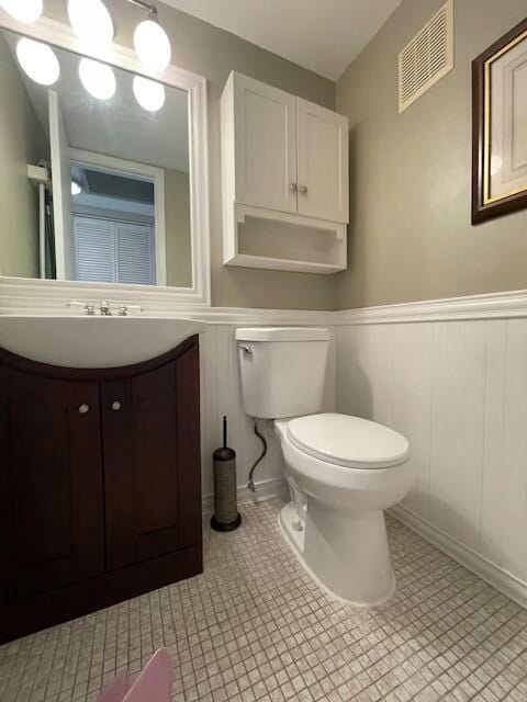 bathroom with tile patterned flooring, vanity, and toilet