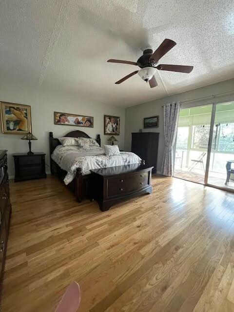 bedroom featuring ceiling fan, light wood-type flooring, a textured ceiling, and access to outside