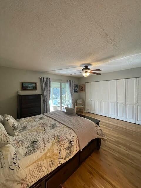 bedroom with ceiling fan, wood-type flooring, and a textured ceiling