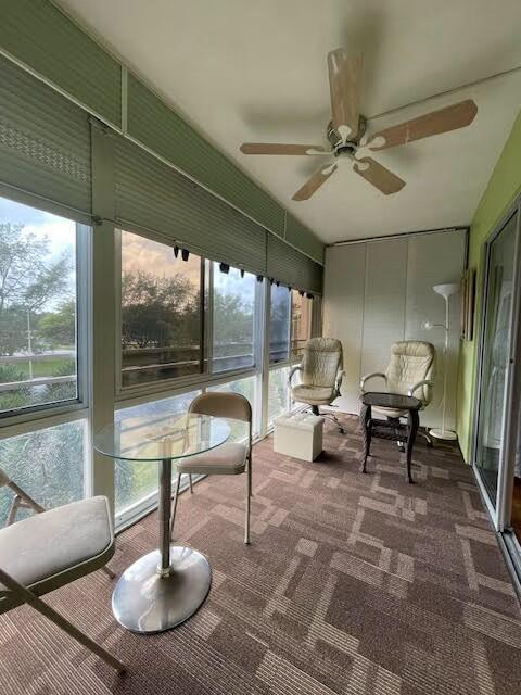 sunroom / solarium featuring ceiling fan