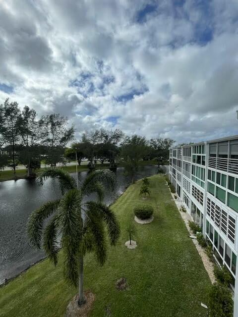 view of community with a lawn and a water view