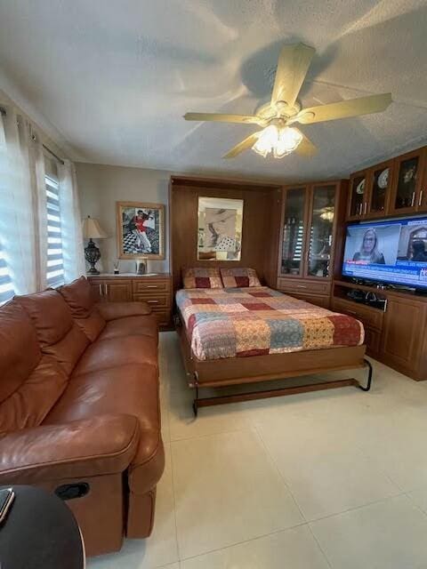 tiled bedroom featuring ceiling fan and a textured ceiling